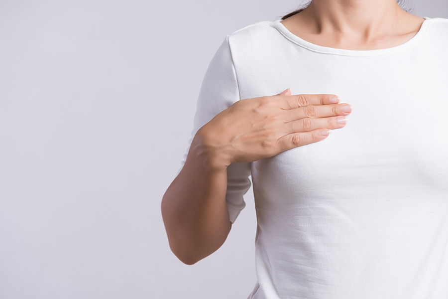 Woman Hand Checking Lumps On Her Breast For Signs Of Breast Cancer