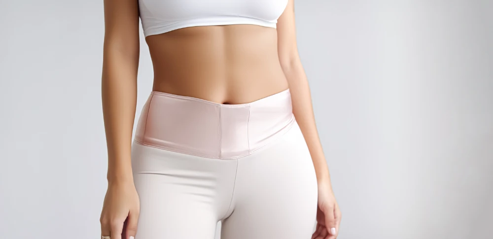 A woman showing her slim waist. Beautiful slim woman body in sportswear