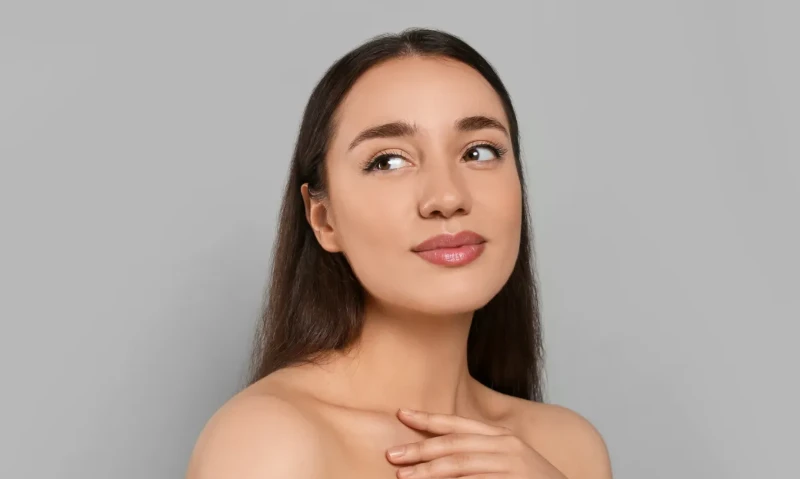 Portrait of beautiful young woman with elegant makeup on grey background