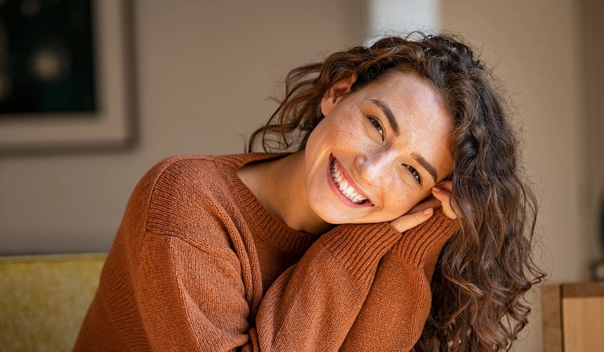 A happy and confident mother with a natural smile, representing the rejuvenating and confidence-boosting results of a mommy makeover.